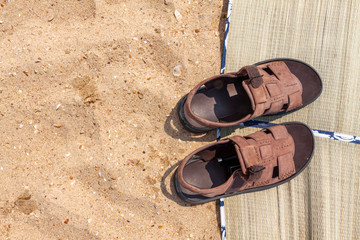 Flip-flops and beach litter on a sandy beach.