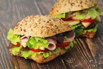 Two sandwiches with whole grain bread, ham and vegetables