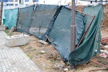 A mess at a construction site with scattered building materials and rubbish with dirt, poor safety...