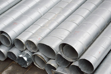 Large iron metal tin corrugated ventilation pipes of large diameter for the industrial construction of ventilation at a construction site during the repair