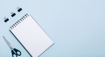 Office supplies in blue background. Flat lay, top view