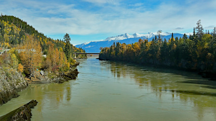 River, bridge and forests with snow capped mountains