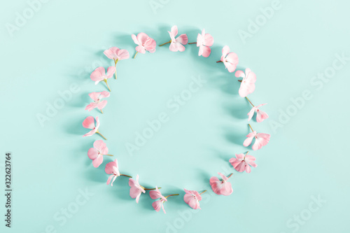 Spring flowers composition. Wreath made of light pink flowers on pastel blue background. Wedding. Valentines Day. Mother's day. March 8. Flat lay, top view, copy space