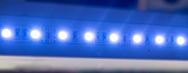 turn on shining colorful led strip light installed on furniture in dark room, wide banner