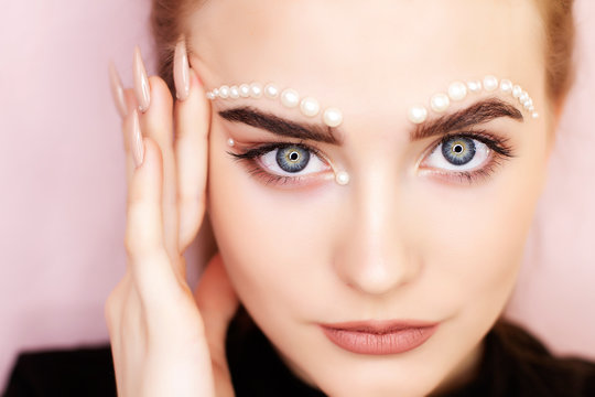 Makeup with pearl rhinestones on the face. Decorative make-up. Creative makeup idea.