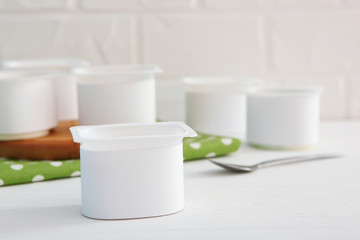 Tasty yogurt in a plastic glass on a colored table. Place to insert text. Useful snack.