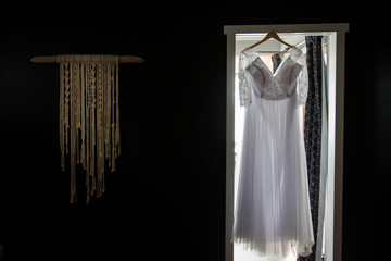 backlit shot of grogeous white wedding dress