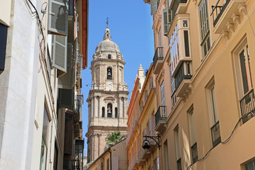 Fototapeta premium Looking towards the Cathedral through the city narrow streets, in the downtown, Malaga, Andalusia, Southern Spain.
