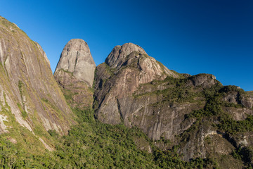 Beautiful view to dramatic rocky mountain peaks over green rainforest