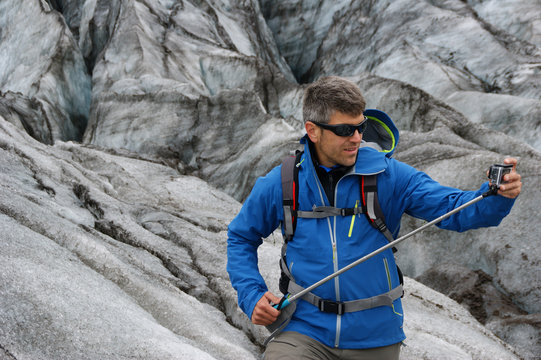 A man  an action with a camera in Skaftafell glacier in Vatnajokull