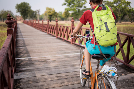 A young female cycling at the Sukhothai Historical site, Sukhothai, Thailand.