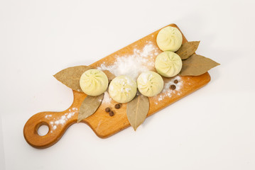 Semi-finished products: Georgian khinkali on a wooden cutting board