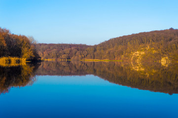 Autumn landscape. The lake reflects the autumn forest.