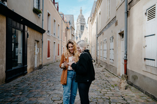Young women looking for direction on their smartphone in a french town