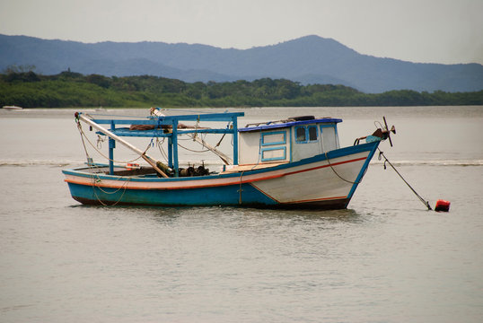 hing boats anchored in the river, floating peacefully in harbor.