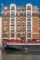 Fototapeta na wymiar Paris, France - 04 14 2019: Building facade along the Canal de L'Ourcq