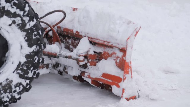 Snow plow tractor cleans road from snow in the winter