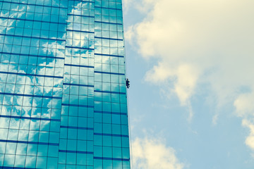 blue sky and clouds reflected in windows of modern building