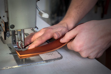 Close up of a leather master sewing leather goods