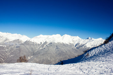 Obraz premium Beautiful view of the snowy mountain peak in the Alps. Wonderful sunny weather. Sochi