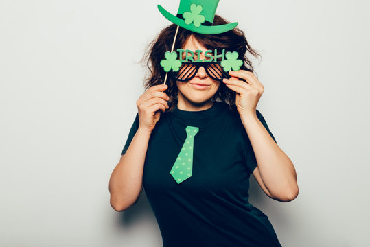 Young girl is preparing for the St Patricks Day party with photo booth props, Ireland traditional holiday, 17 March