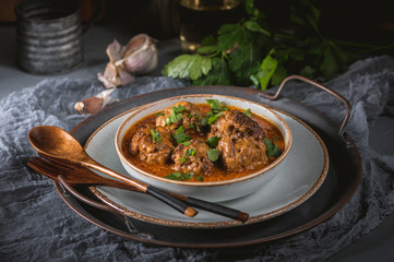 Tasty homemade meatballs with tomato sauce and herbs served in a plate