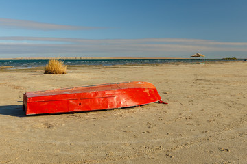 red boat lies on the lake
