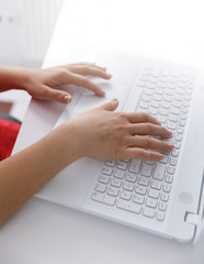 hands typing on white laptop 