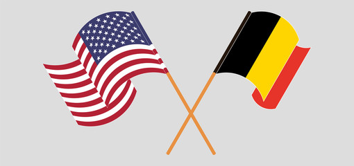 Crossed and waving flags of Belgium and the USA