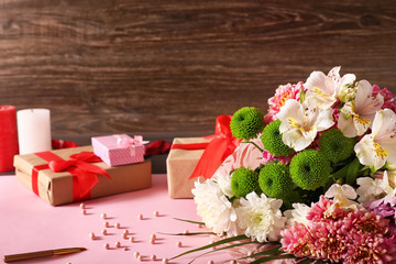 Box with a gift, cosmetics and flowers on a pink and dark background