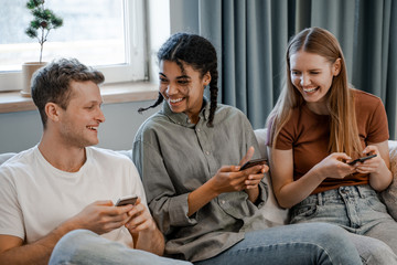 Modern conversation. Internet and social networks online bondage problem. International friendship, happy time together, friends having relax time. Enjoy communication and holiday. Three friends