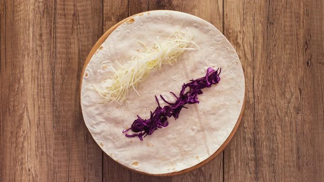 Making a kebab or gyros - a traditional roll sandwich wrapped in wheat flour wraps and various fresh ingredients - top view, flat lay