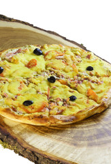 Sliced pizza with sausage, bacon, olives and tomatoes is on a wooden table. Fast food
