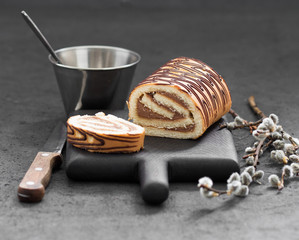 Cake roll chocolate cream on a dark background