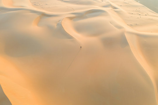 Aerial view of a man walking on sand dunes Eastern Mahadir, Abu Dhabi, United Arab Emirates