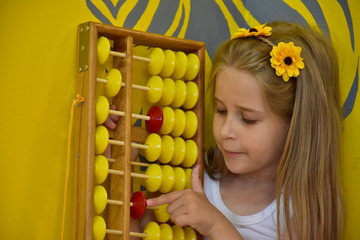 little girl with a wreath on her head and an abacus,