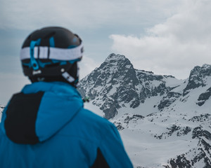 Fototapeta na wymiar persona mirando hacia la nada en la montaña en invierno. La persona lleva equipo de esquiar en un ambiento nevado i con un sentimiento helado
