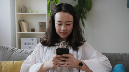 Close-up footage of young fabulous Chinese woman in white blouse. Portrait of focused girl working...