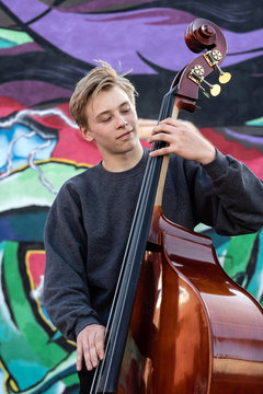 High school jazz band musician playing double bass by graffiti