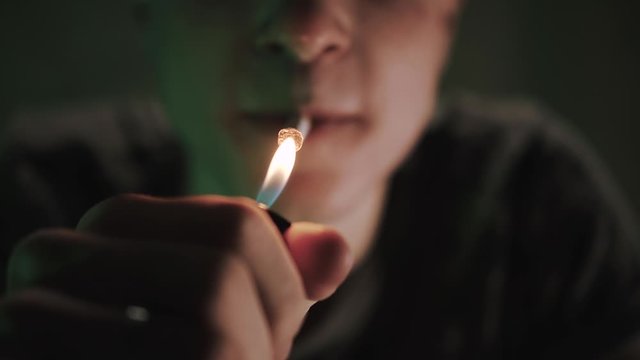 Teenager lighting a cigarette and smoking it
