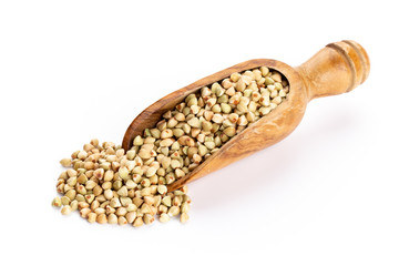 Raw buckwheat and wooden spoon on white background.