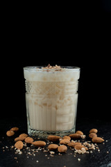Alcoholic cocktail with almond, gin and almond milk on black background
