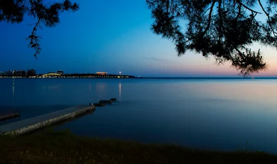 Foto op Canvas the Gelendzhik Bay of the twilight. calm. sky blue. in the background, the Gelendzhik lighthouse. the lights of the promenade, hotels and resorts © Александр Трихонюк