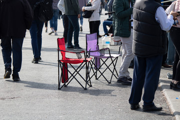 Foldable chair in pink and red. Made of nylon fabric and metal pipes. It can be used for trips and camping areas.