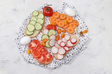 Useful breakfast, fried bread, carrots and cucumbers, tomatoes and radishes, eggs, green sandwiches, fermented foods, the concept of a healthy diet and weight loss, diet mini-sandwiches 