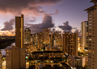 Dawn or sunrise behind the hotels and apartments in the modern part of Waikiki by the canal on Oahu