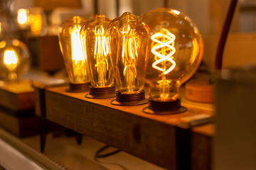 close-up of vintage light bulb with industrial wooden base