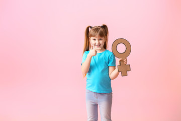 Little girl with symbol of woman on color background. Concept of feminism