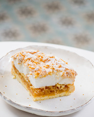 piece of puff cake with white meringue and a layer of apple filling