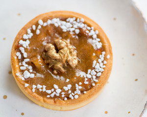 tartlet with caramel and walnut sprinkled with golden powder